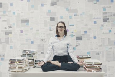Şirketin iş kadını ofiste meditasyon yapıyor.