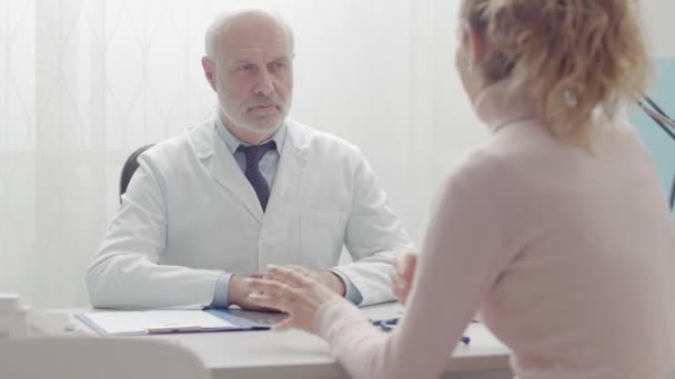 Зустріч лікаря та пацієнта в офісі для консультації — стокове відео