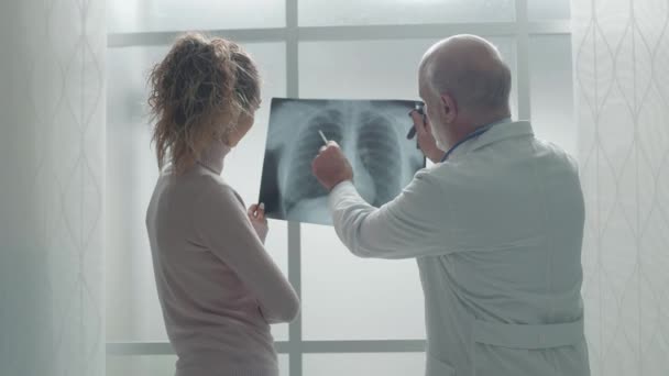 Doctor examining a patient's x-ray during a visit — Stock Video