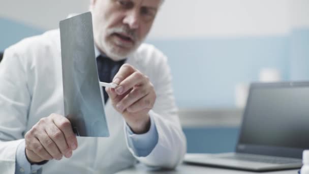 Врач проверяет рентгенографию пациента и дает объяснения — стоковое видео