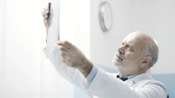 Professionele arts die de radiografie van een patiënt controleert — Stockfoto