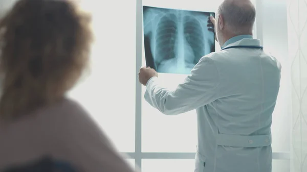 Профессиональный врач проверяет рентгенографию пациента — стоковое фото