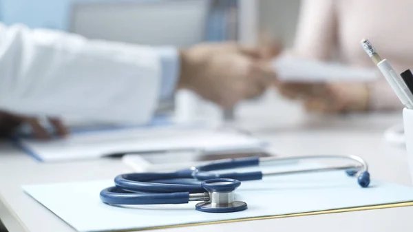 Médico profissional que dá uma receita a um paciente — Fotografia de Stock