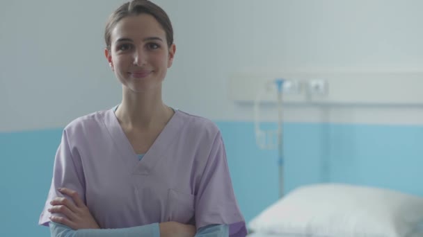 Profesionální mladá sestra s úsměvem a pózování v nemocnici — Stock video