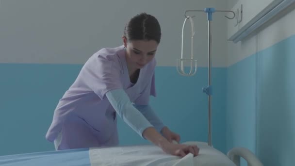 Enfermera experta haciendo la cama en el hospital — Vídeo de stock