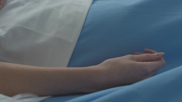 Ranna kobieta leżąca w szpitalnym łóżku z kołnierzem szyjnym i kroplówką. — Wideo stockowe