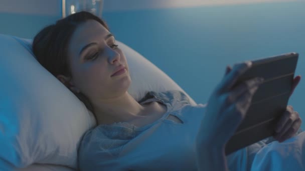 Fiatal beteg fekszik az ágyban a kórházban, és csatlakozik egy tabletta — Stock videók
