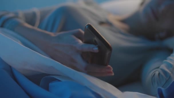 Jonge patiënt ligt in bed in het ziekenhuis en chatten met haar telefoon — Stockvideo