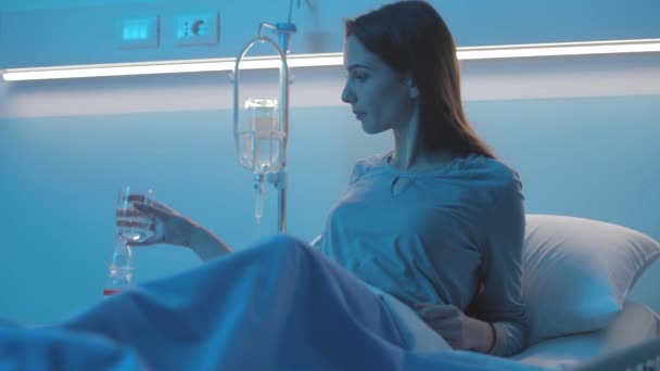 Paciente joven bebiendo agua en el hospital — Vídeos de Stock