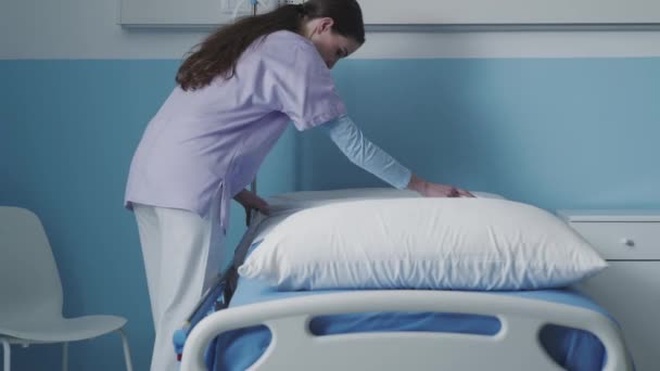 Pielęgniarka ścieli łóżko w szpitalu. — Wideo stockowe