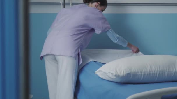 Enfermera experta haciendo la cama en el hospital — Vídeo de stock