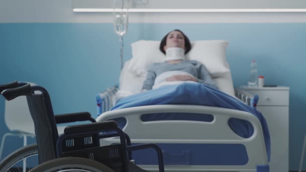Mujer lesionada acostada en una cama de hospital con cuello cervical y IV — Vídeo de stock