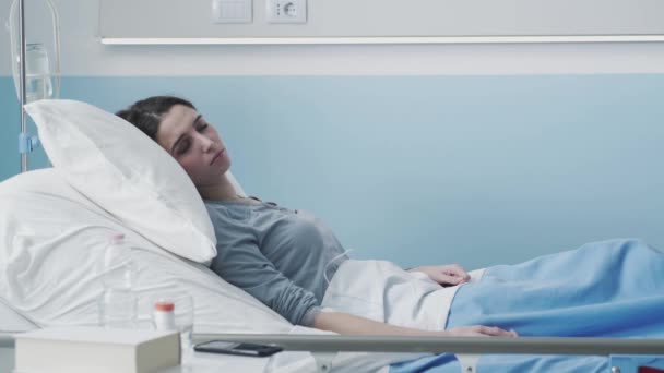 Paciente jovem deitado na cama e recebendo terapia IV — Vídeo de Stock