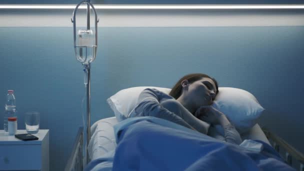 Mujer acostada en la cama del hospital y recibiendo terapia intravenosa — Vídeos de Stock