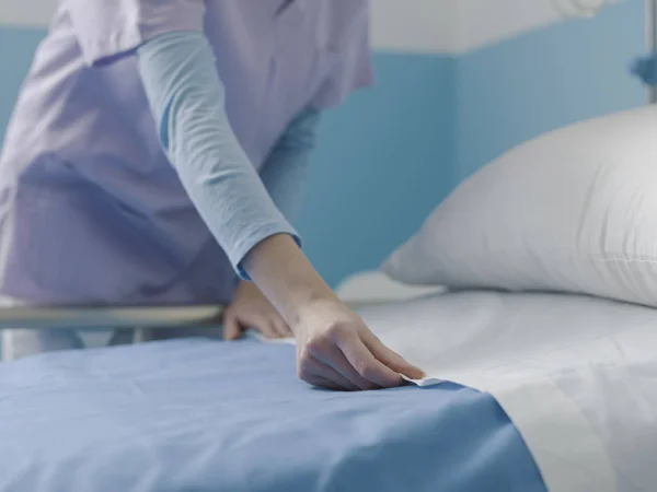 Enfermeira especialista fazendo a cama no hospital — Fotografia de Stock