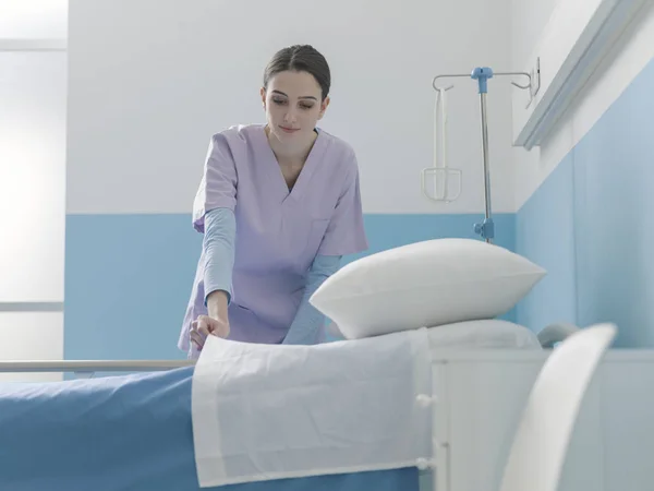 Asiantuntija nuori sairaanhoitaja petaa sängyn sairaalassa — kuvapankkivalokuva