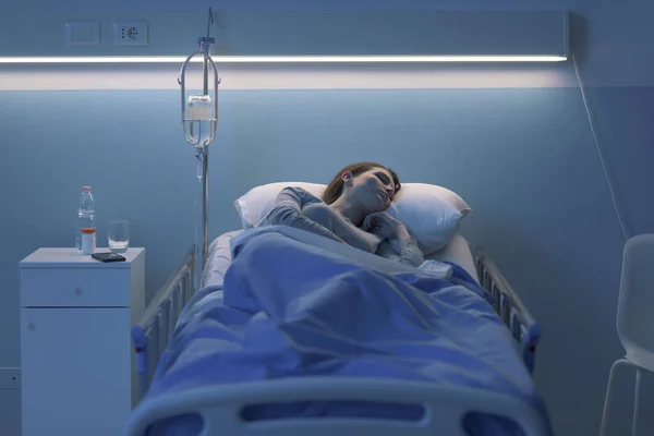 Wanita berbaring di tempat tidur rumah sakit dan tidur dengan infus — Stok Foto