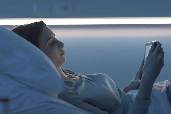 Jonge slapeloze patiënt in het ziekenhuis die verbinding maakt met een tablet — Stockfoto