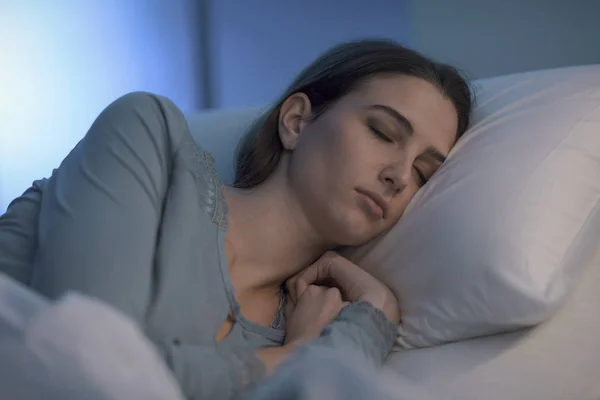Genç bir kadın gece hastane yatağında yatıyor. — Stok fotoğraf