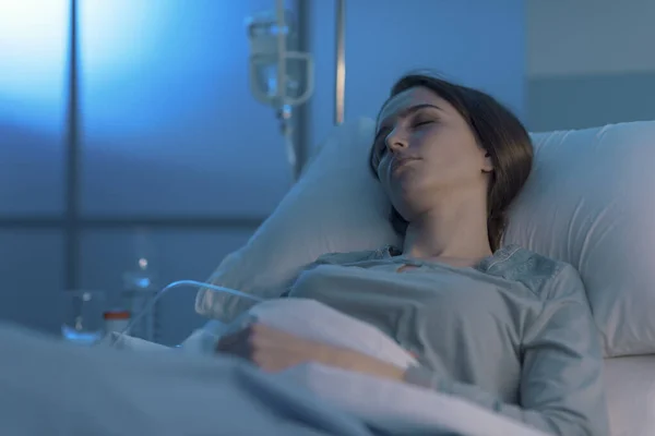 Kvinna som ligger i sjukhussängen och sover med dropp — Stockfoto
