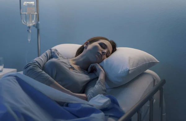 Γυναίκα ξαπλωμένη στο κρεβάτι του νοσοκομείου και κοιμάται με τον ορό. — Φωτογραφία Αρχείου