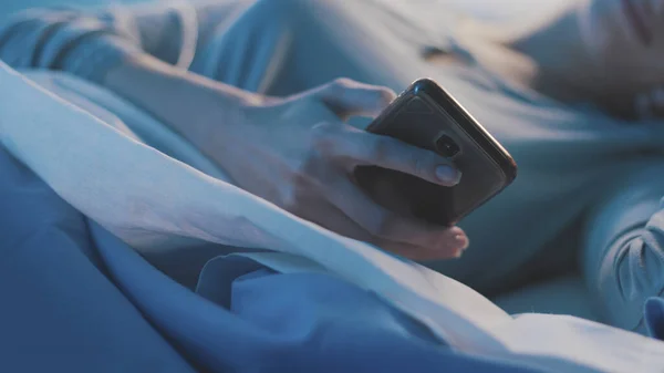 Paciente deitada na cama do hospital e conectando-se com sua sma — Fotografia de Stock
