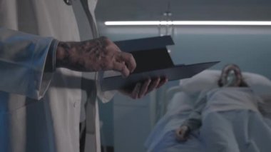 Profesyonel doktor gece hastanede yatan bir hastayı kontrol ediyor.