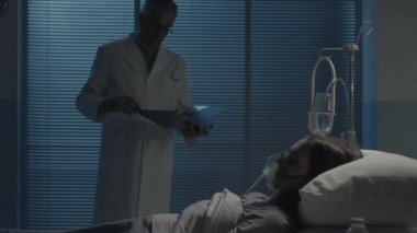 Profesyonel doktor gece hastanede yatan bir hastayı kontrol ediyor.