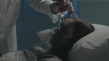 Doktor hastane yatağında bir hastayı kontrol ediyor.