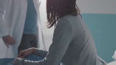 Doktor hastanede bir hastayı rahatlatıyor.