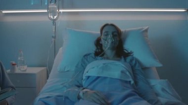 Babası hasta kızına hastanede yardım ediyor.