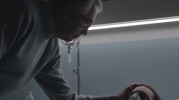 Чоловік перевіряє хвору жінку в лікарні — стокове відео