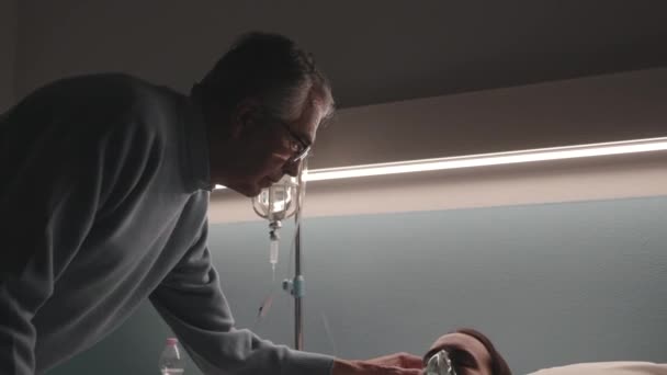 Liefdevolle vader assisteert haar zieke dochter in het ziekenhuis — Stockvideo