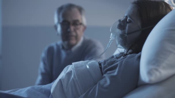 Mannen kollar en sjuk kvinna på sjukhuset — Stockvideo