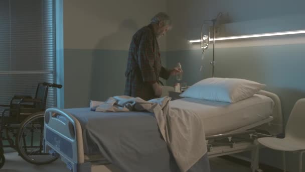 Schlafloser Senior im Krankenhaus trinkt Wasser — Stockvideo