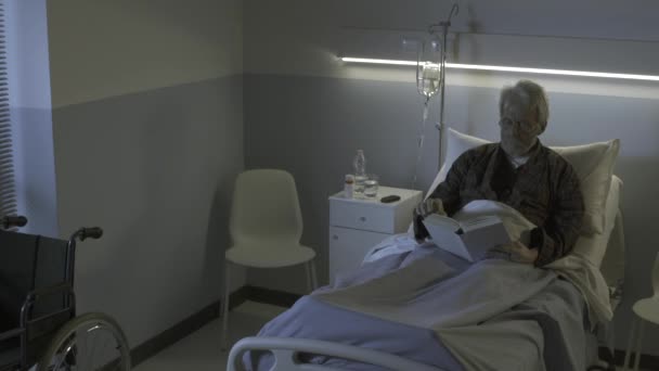 Egy álmatlan öregember a kórházban könyvet olvas.