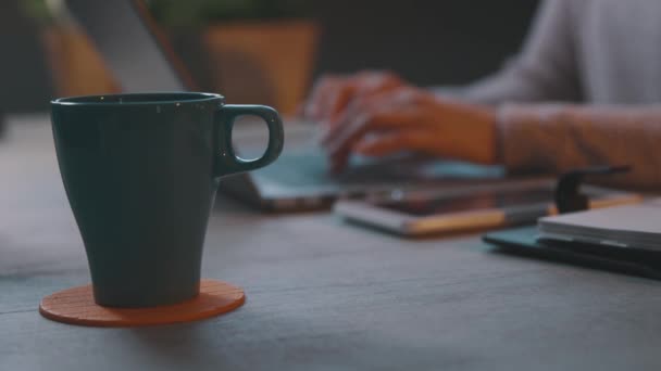 Vrouw werkt met haar laptop en het drinken van koffie — Stockvideo