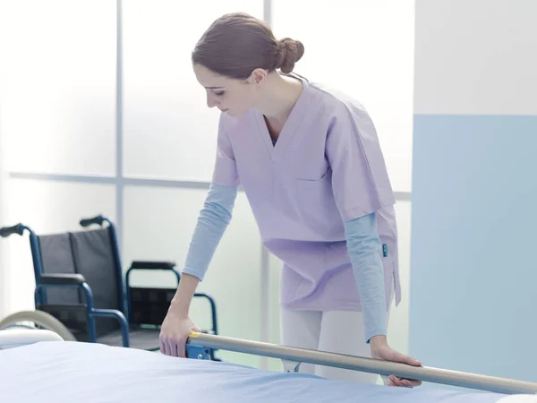 Enfermeira Trabalhando Hospital Arrumando Sala Ela Está Ajustando Trilhos Cama — Fotografia de Stock