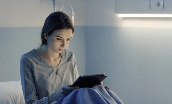 Geceleri Hastane Yatağında Yatan Genç Uykusuz Hasta Dijital Tabletine Bağlanıyor — Stok fotoğraf