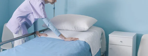 病院で働く専門家の若い看護師 彼女はベッドを作ってシートを交換しています 医療サービスと支援の概念 — ストック写真