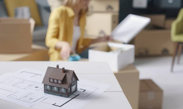 People moving in a new house, project and model home in the foreground, home renovation and relocation concept