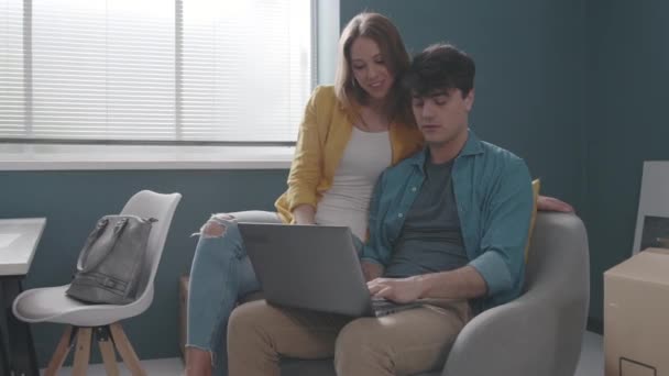 Jong stel verhuizen in hun nieuwe huis en online verbinding maken — Stockvideo