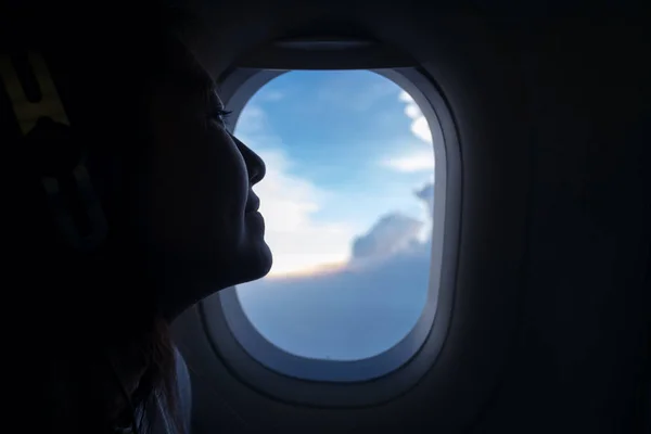 Mujer sentada junto a la ventana del avión — Foto de Stock