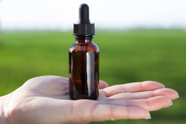 Avucundaki şişede taze kozmetik ürünler..