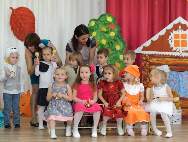Karnaval kostümleri ve iki kadın giymiş on küçük çocuk