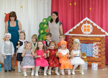 Karnaval kostümleri ve iki kadın giymiş on küçük çocuk