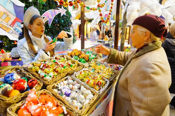 Elderly woman buys Christmas toy on New Year fair — Stock Photo, Image
