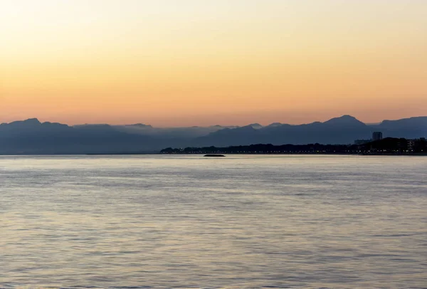 Färgglada dark solnedgång över havet och bergen — Stockfoto