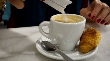 Kadın el karıştırarak şeker içine kahve latte.