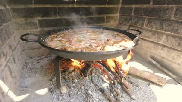 Typische en traditionele Spaanse paella, koken met natuurlijke brand — Stockvideo